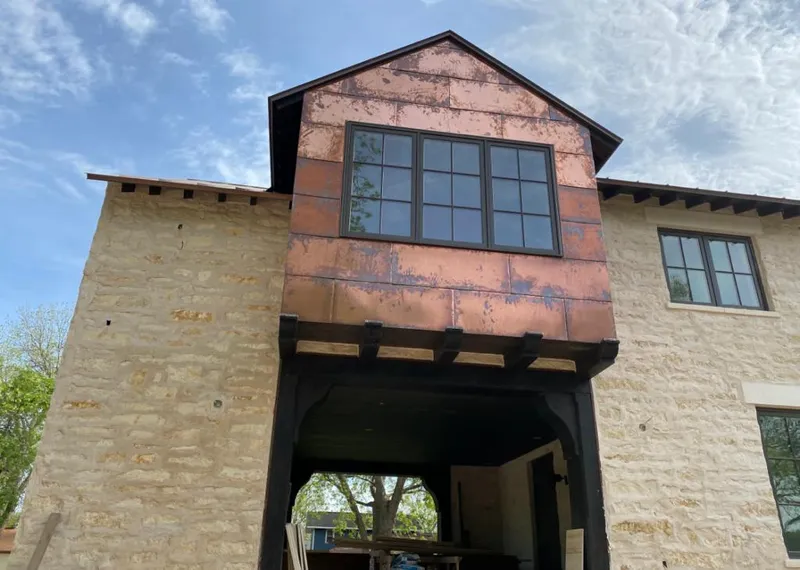 Copper metal panel facade on a stone building for Roof Repair in Mounds View